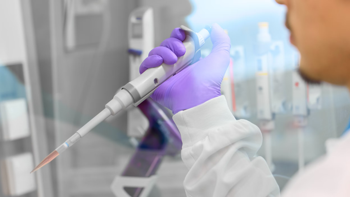 Scientist using pipette for gene-editing research in laboratory